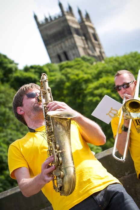 Single trombone player in front of Durham Cathedral