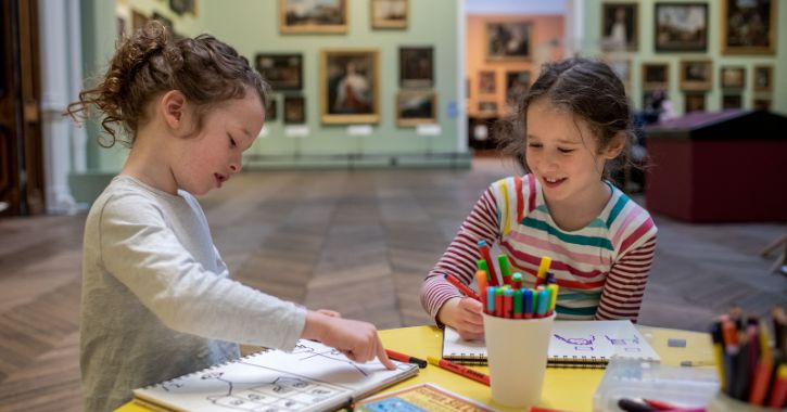 Young girls sitting at a table drawing