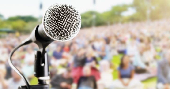 A microphone with a festival audience blured in the background