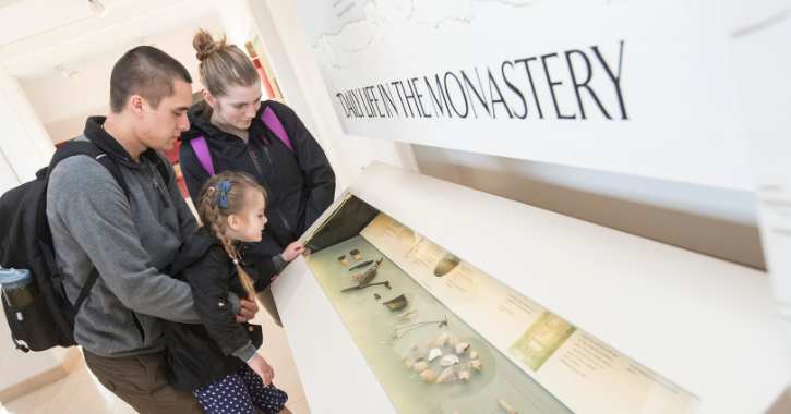Family looking at display at Bede Museum in Jarrow Hall