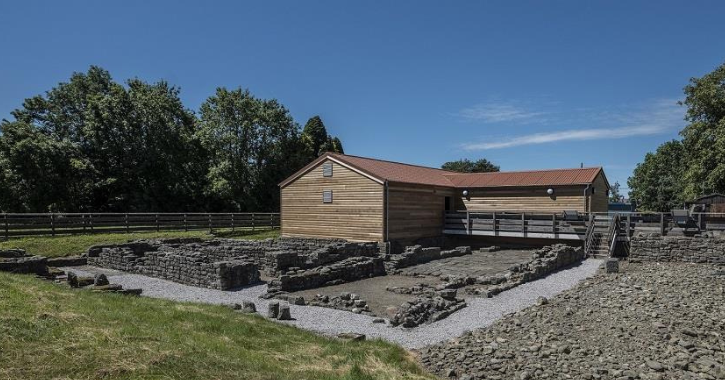 Exterior of Binchester Roman Fort showing Roman ruins and wood cabin