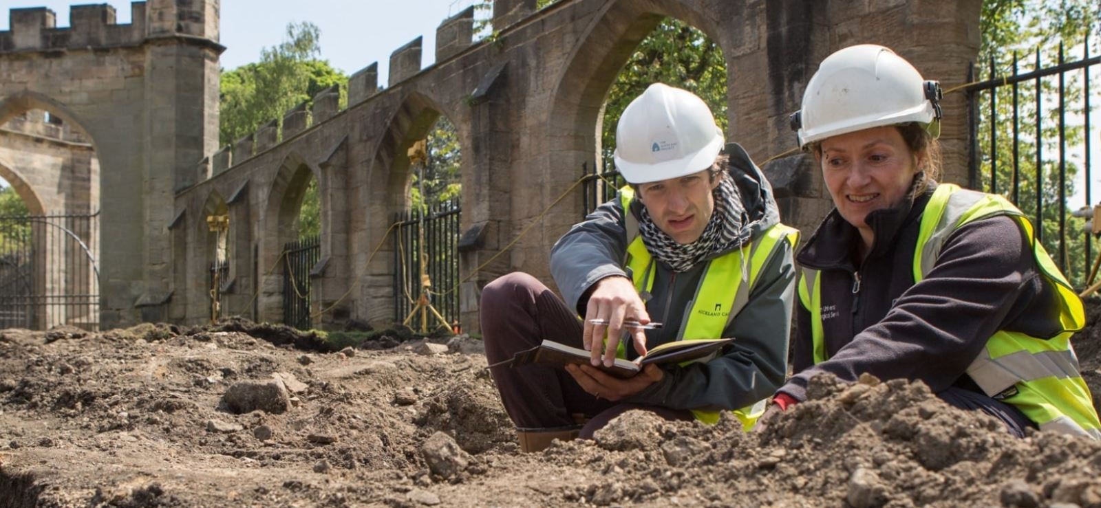 Two people in a hole at Auckland Castle