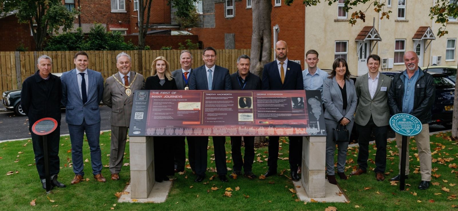 A group of people standing with the plaques