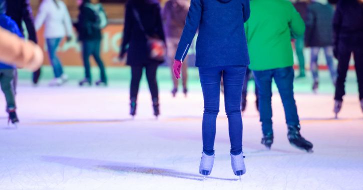 close up shot of people's legs as they ice skate