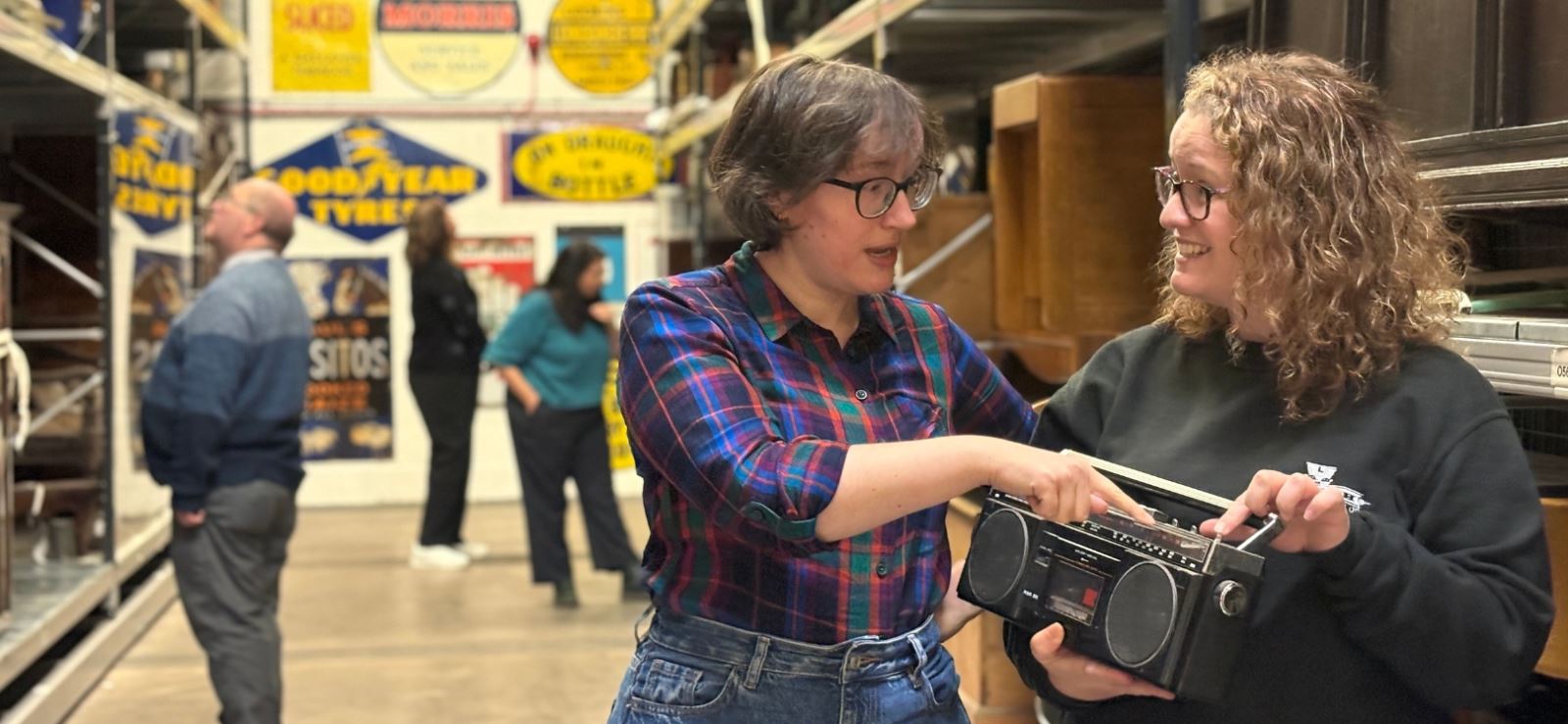 Two people holding an old radio