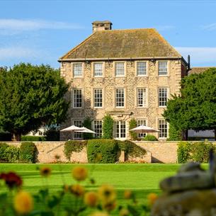 Exterior view of Headlam Hall, blue skies with gardens in foreground.