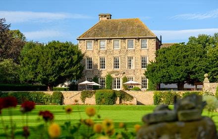 Exterior view of Headlam Hall, blue skies with gardens in foreground.