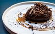 A plate of malted chocolate mousse with coffee and syrup and malted chocolate crumb.