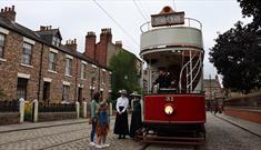 Image of the 1900s Town Street at Beamish Museum, people waiting to board the tram.