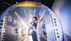 A man and a child playing in a replica of the International Space Station at the Life Science Centre.