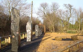 Image by Jack Turton. Stone monoliths decorated with mining paraphernalia.