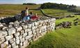 Image of a family at Housesteads Roman Fort, looking out towards Hadrian's Wall. English Heritage.