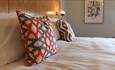 Orange and grey geometric print cushions on the comfortable beds at The Park Head Hotel.