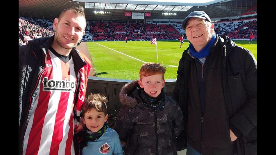 Two men and two young boys in the stadium of light